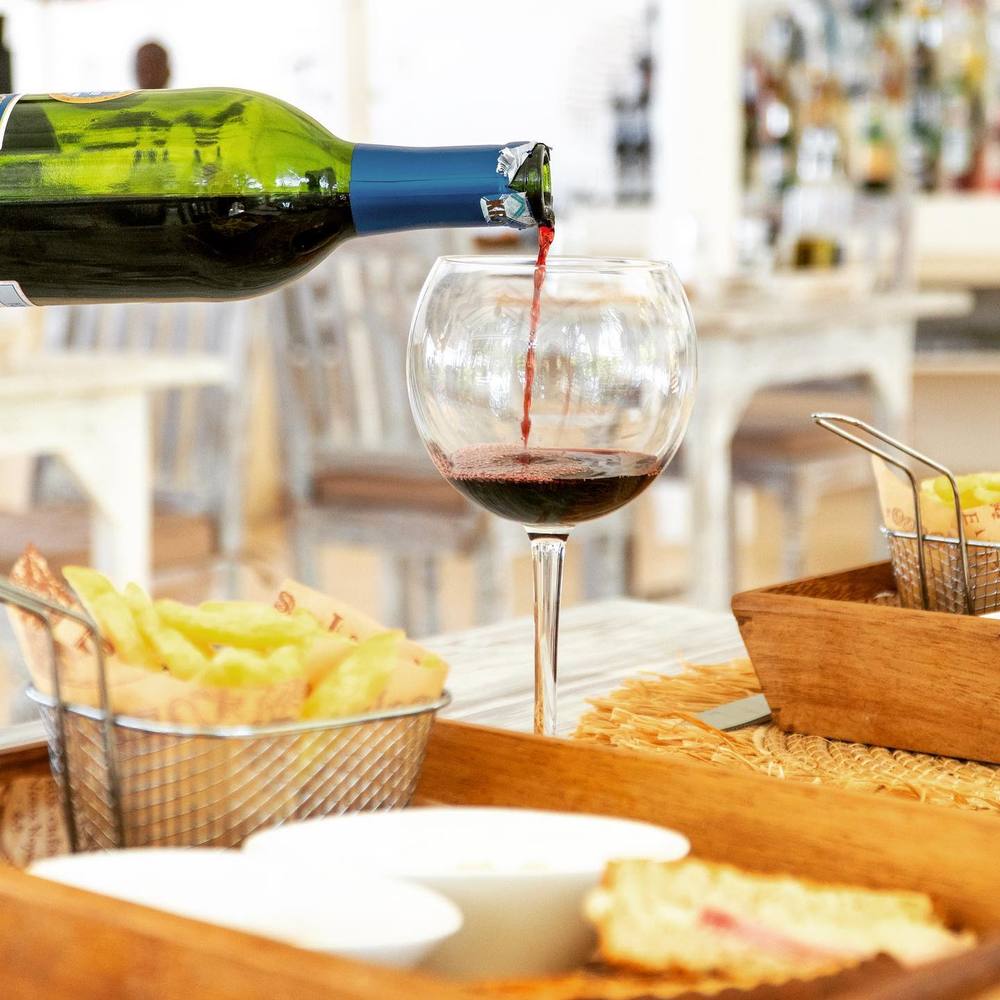 A glass of red wine being poured over lunch at Tamu